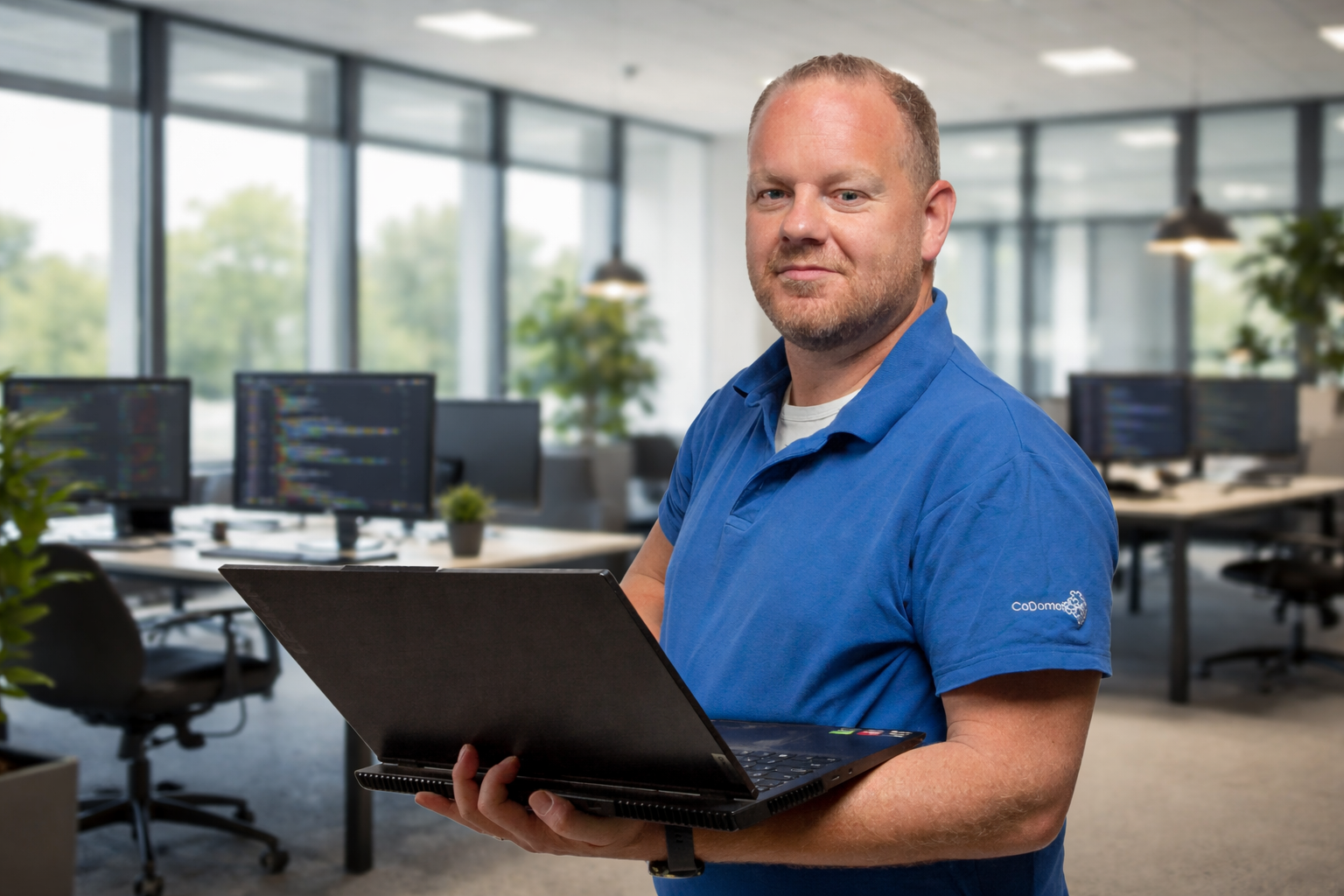 KNX programmeur van CoDomotics werkt met laptop in moderne kantooromgeving aan domotica installatie